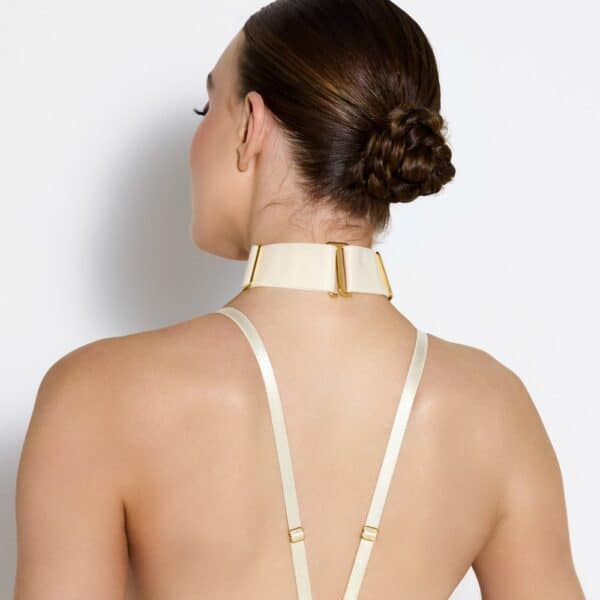 Detail of a Photo of a Woman from the Back Wearing a Crop Top and Necklace with Cream Color Ring