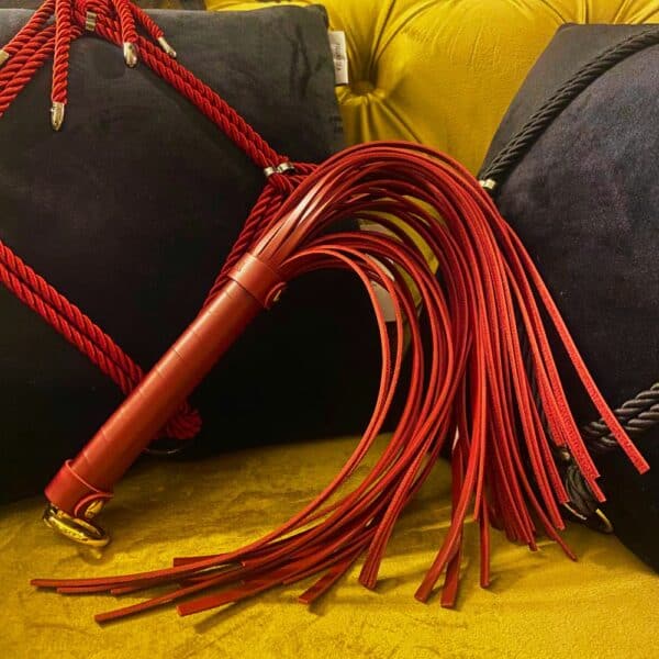 Red BDSM whip on an armchair.