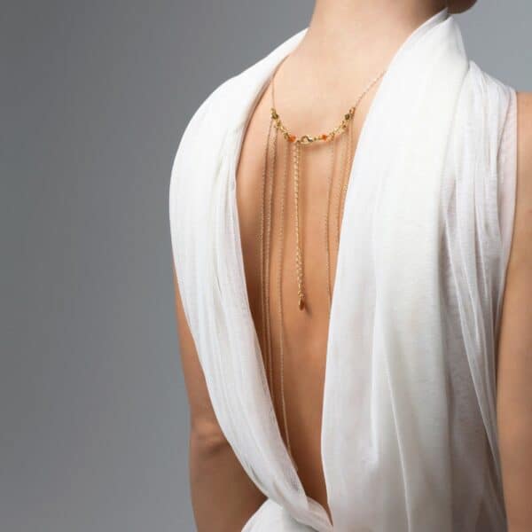 Photo of a 3/4 Back Woman wearing a Gold Bust Jewel with Swarovski Jewelry with a White Outfit