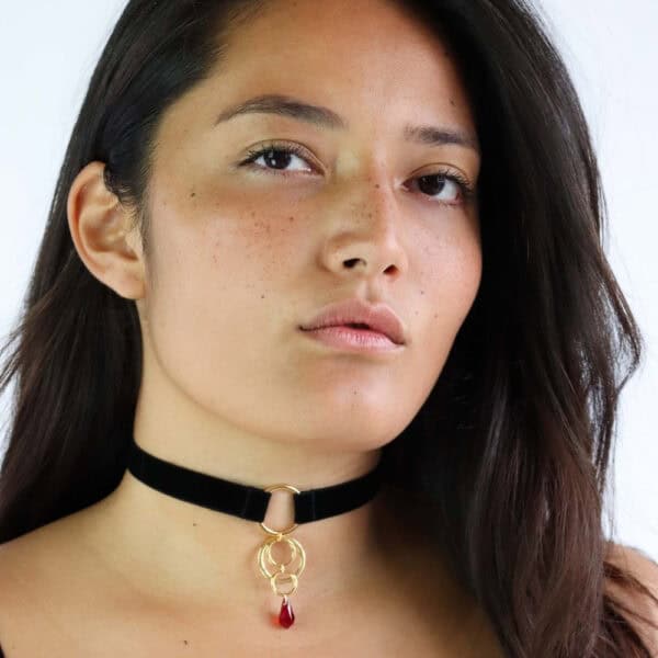 Femme de Devant portant un Choker Noir avec Anneaux Or et Cristal Rouge