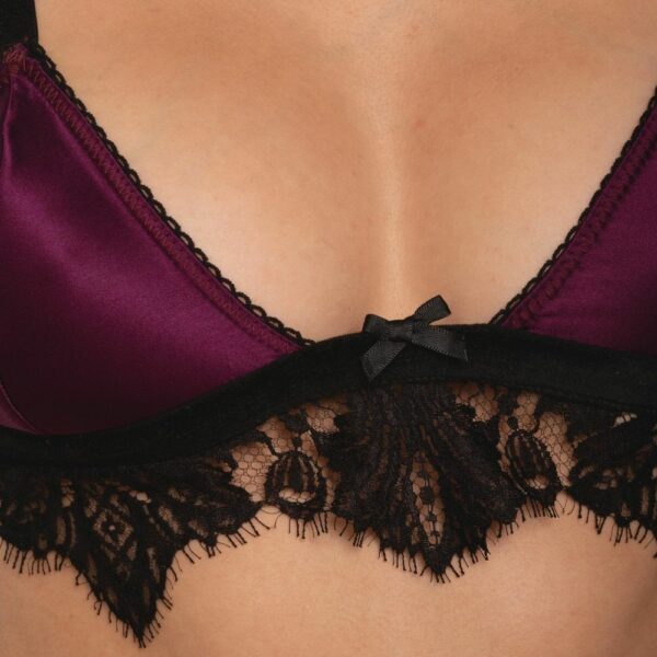 BH-Detail einer Frontfrau, die einen Triangel-Bralette-BH, einen Strapsgürtel und ein offenes Höschen aus violettem Satin und schwarzer Spitze trägt.